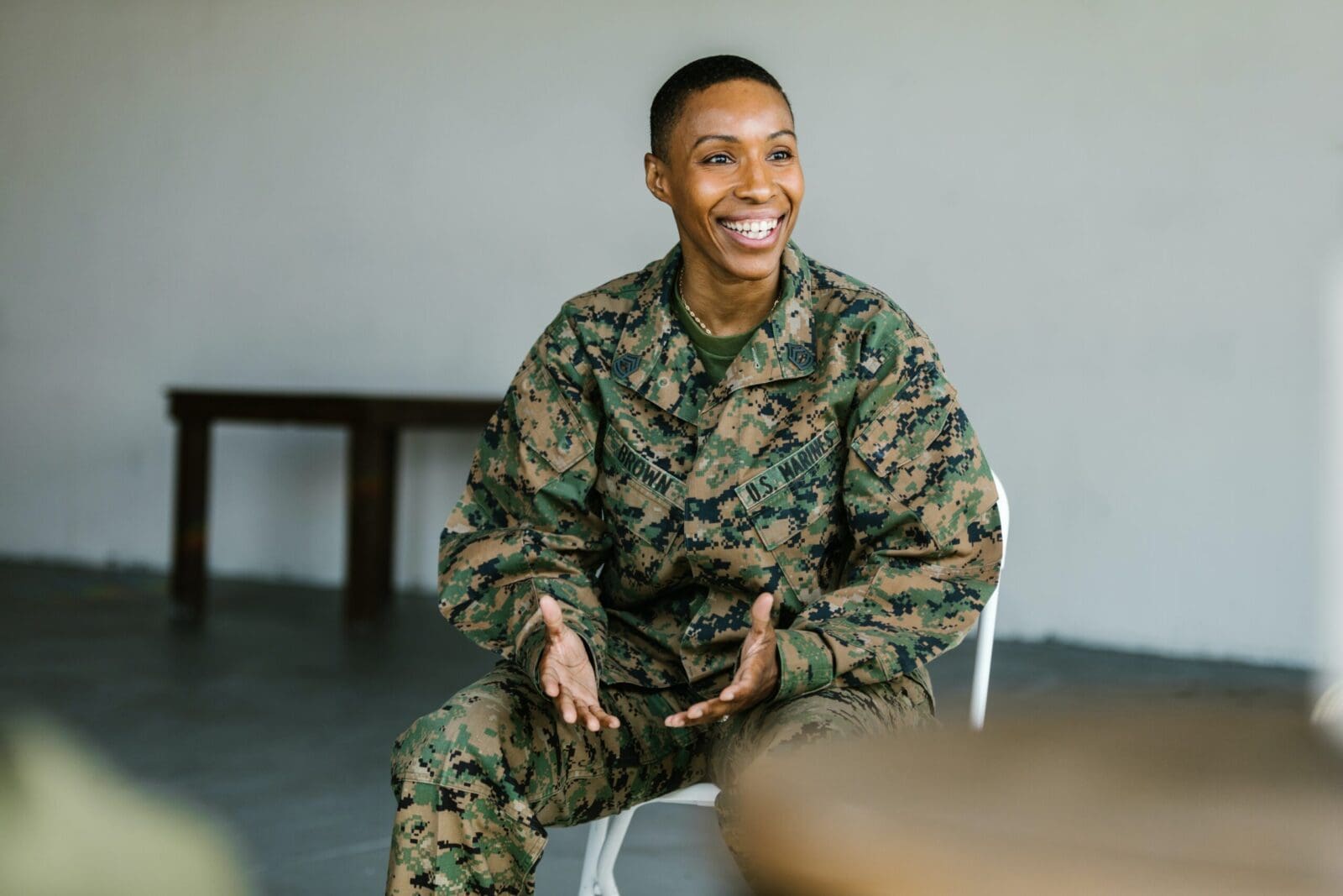 military member sitting in a chair smiling
