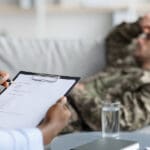 Doctor takes notes while veteran lays on couch talking about a secondary mental health condition