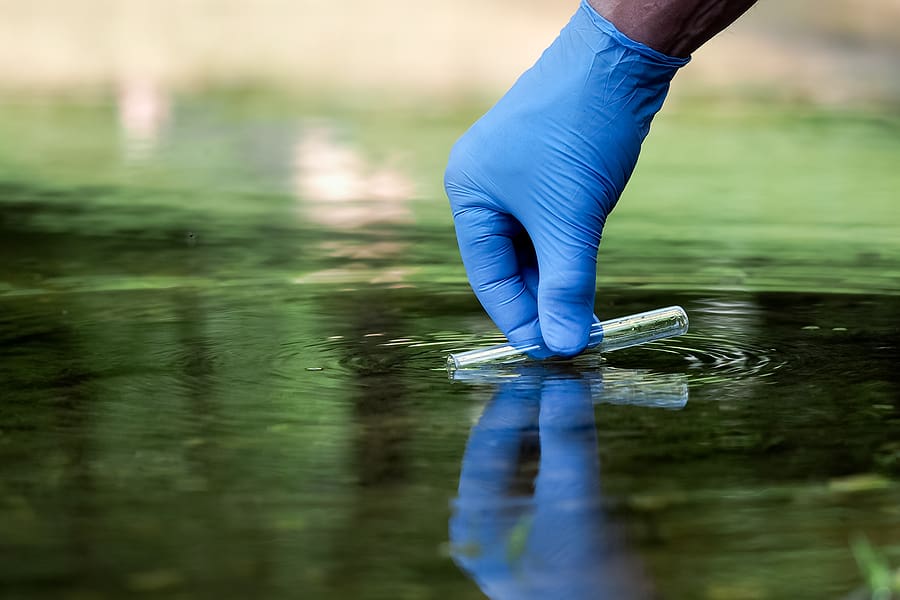 Researcher takes sample of toxic water with a test tube