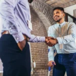 Veteran with a disability using a cane shakes the hand of his VA disability lawyer