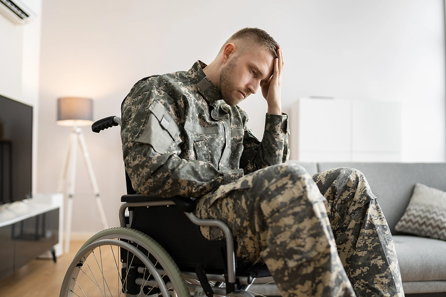 Young male veteran in a wheelchair looking upset dealing with PTSD