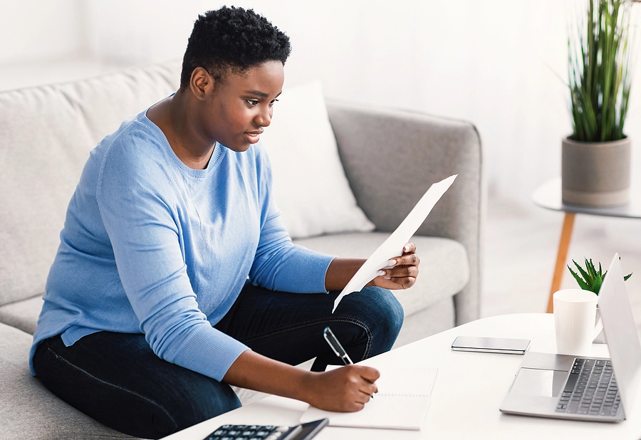 Young black female veteran filing out a veterans disability claim at home