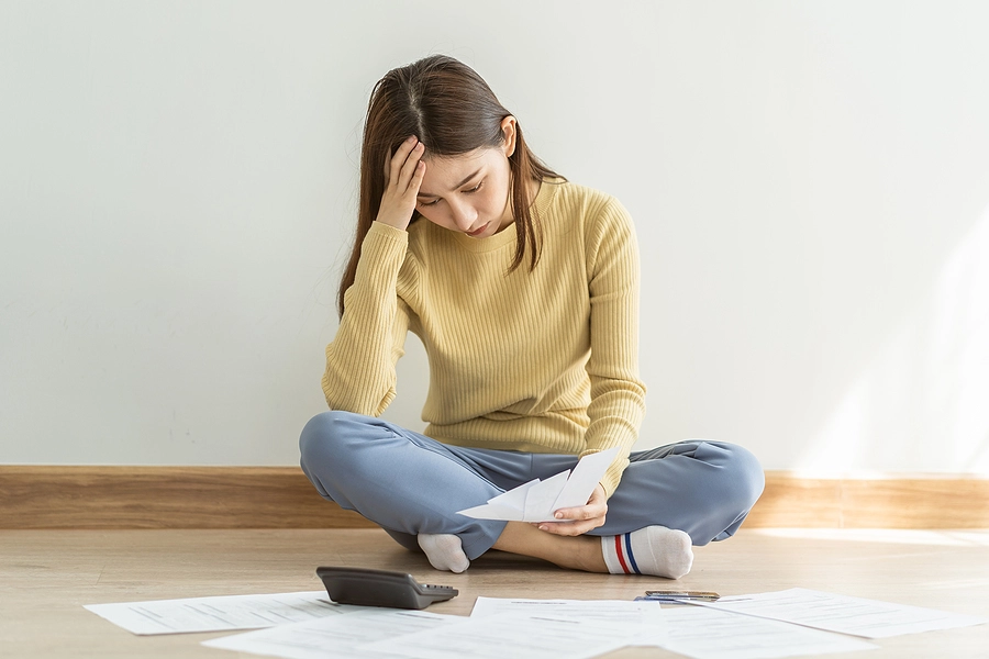 Young female veteran sitting on the floor surrounded by paperwork trying to determine the effective date for her VA disability claim