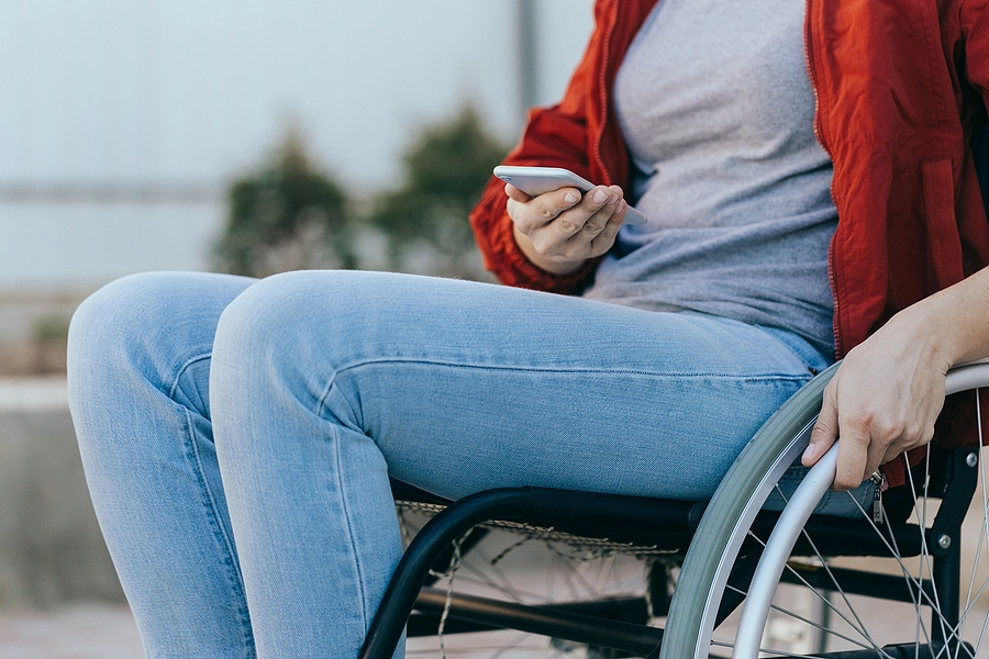 veteran in a wheelchair looking up the 2024 va pay chart on her phone