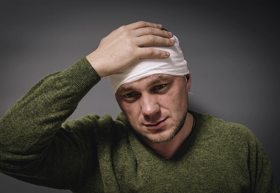 Veteran with service-related disability wearing a head bandage after sustaining a traumatic brain injury