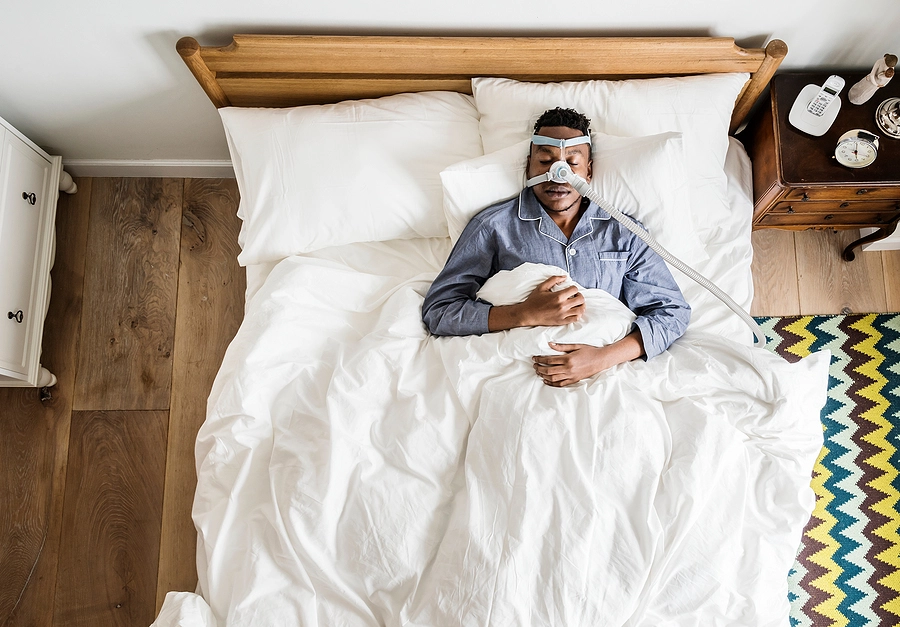 male veteran with sleep apnea wearing a cpap breathing mask to manage his service related sleep disorder