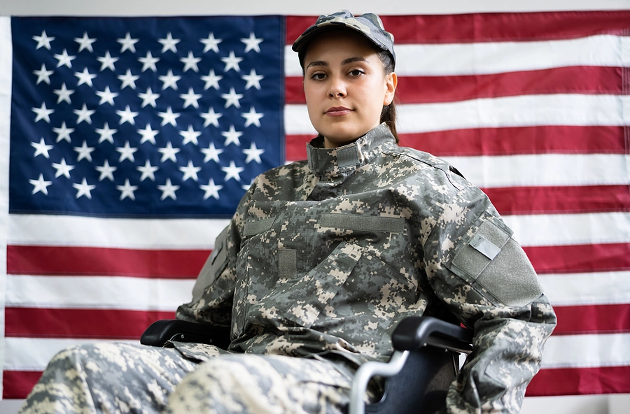 female veteran in a wheelchair in front of a flag receiving disability benefits due to the benefit of the doubt doctrine