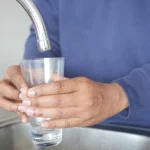person filling up a glass of contaminated water at camp lejeune