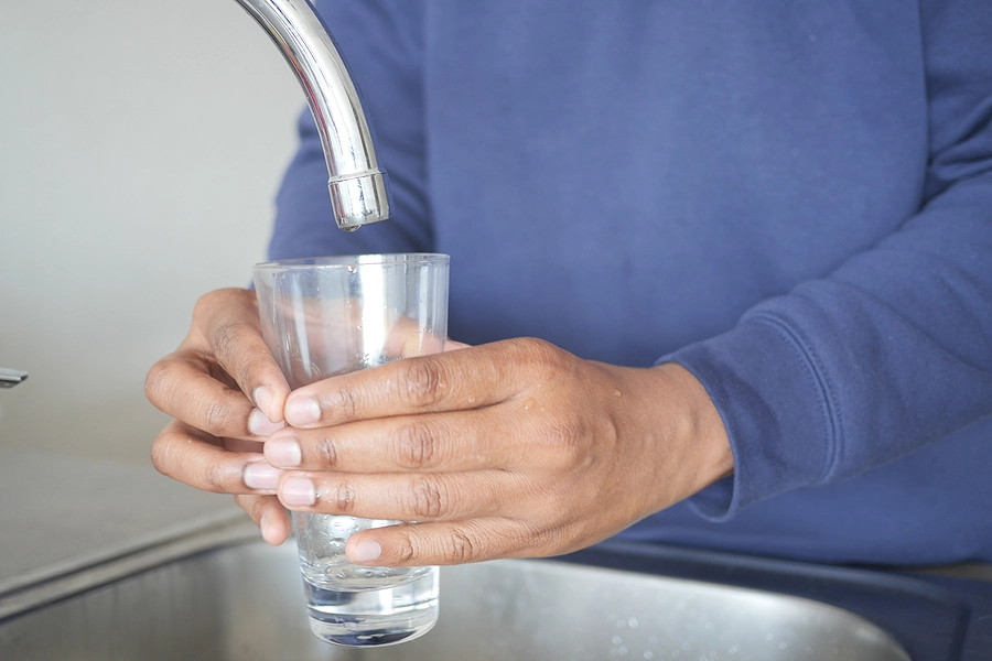 person filling up a glass of contaminated water at camp lejeune