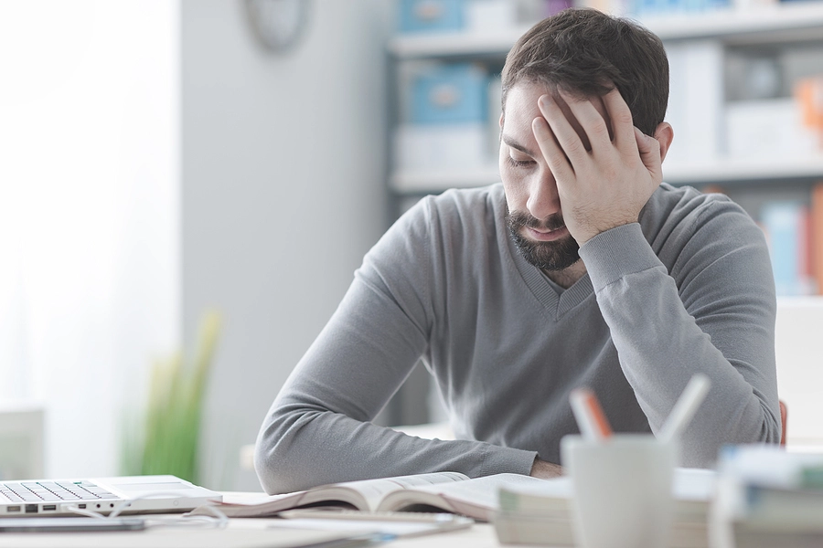 male veteran with chronic fatigue syndrome looking exhausted while trying to work from home